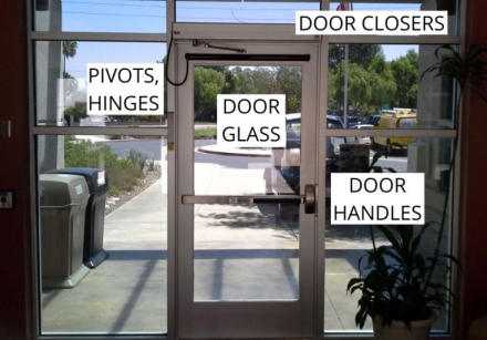 Low angle view of a modern glass tower reflecting city lights and streetscape in downtown urban area.